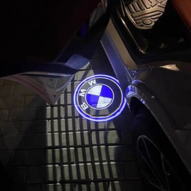 Logo projection from the LED door light shining on the ground at night